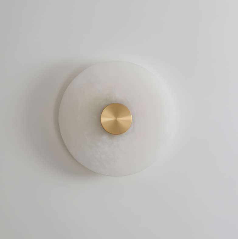 Round wall light fixture with gold accent on a plain wall